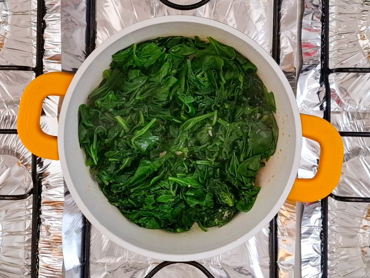 Numa panela, o azeite, o alho e o espinafre.