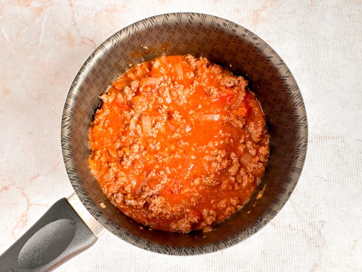 Molho de tomate e tomate pelado adicionados na panela.