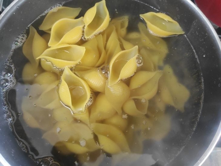 Macarrão cozinhando na panela com água.