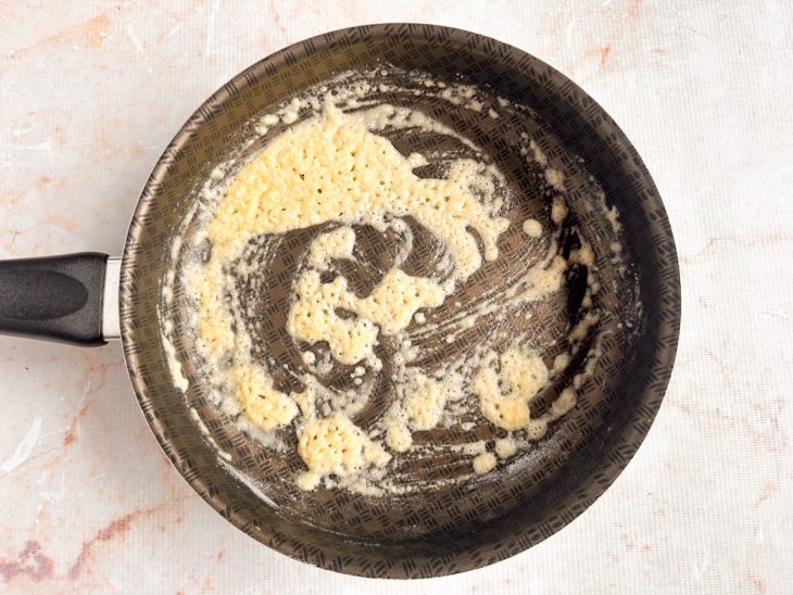 Manteiga derretendo na panela com farinha sendo incorporada.