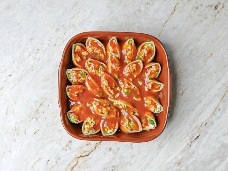 Molho de tomate adicionado sobre os conchigliones.