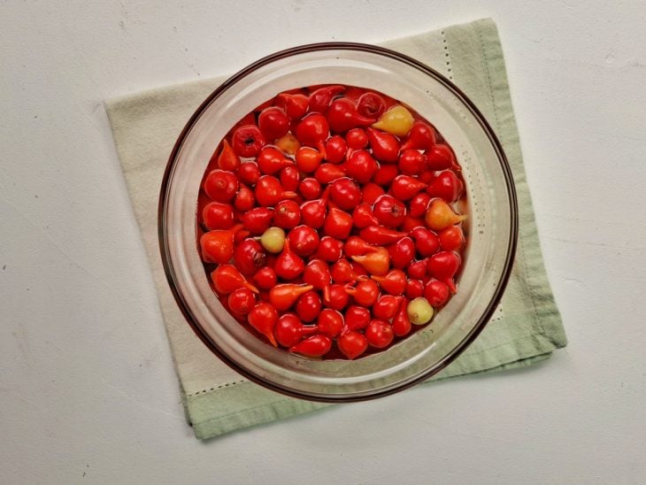 Uma tigela com pimentas e água gelada.