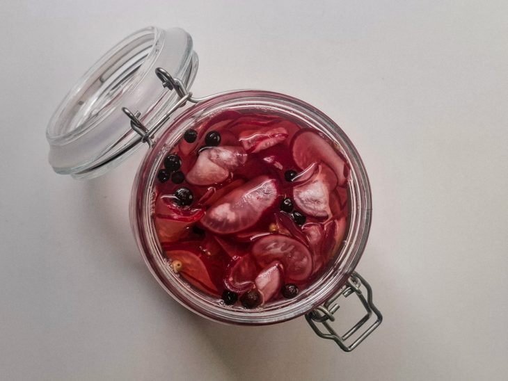 Rabanetes escorridos transferidos para pote hermético, junto ao caldo.