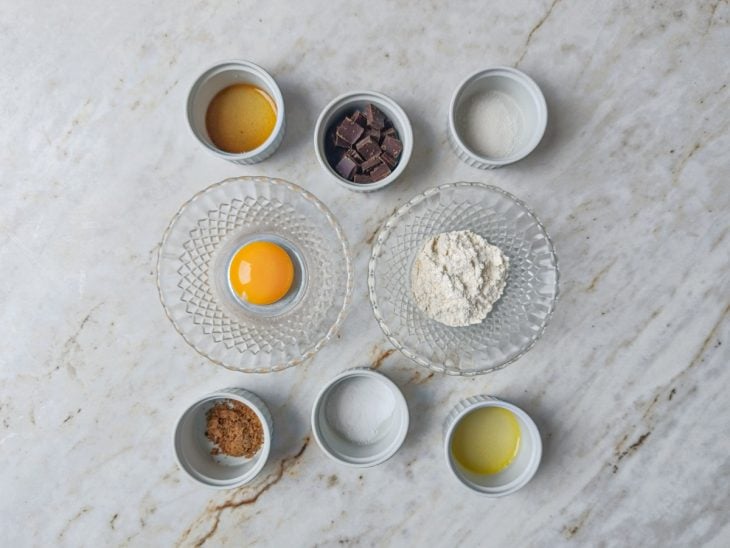 Ingredientes organizados na bancada com chocolate, farinha e açúcares.