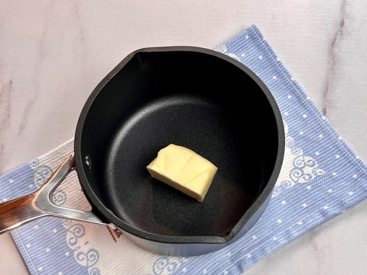 Uma panela contendo um pedaço de manteiga.
