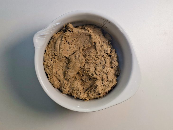 Tigela da massa coberta com plástico filme.