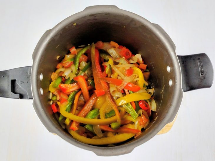 Pimentão e o tomate, adicionados ao alho e a cebola na panela.