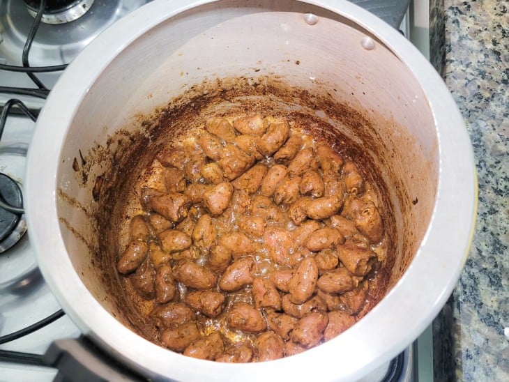 Uma panela de pressão com corações de frango cozidos na pressão.