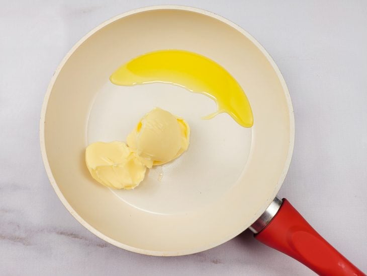 Uma frigideira derretendo manteiga com azeite.