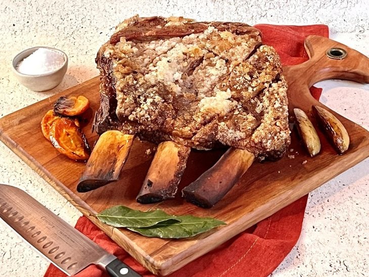 Uma tábua com uma peça de costela assada no forno.