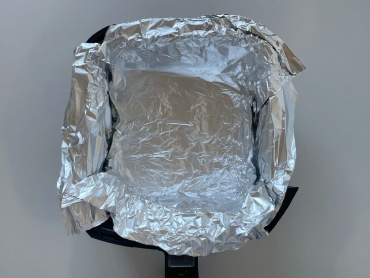 Cesta da air fryer forrado com papel alumínio.