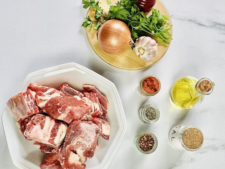 Ingredientes para a receita de costela na panela de pressão elétrica reunidos em uma bancada.