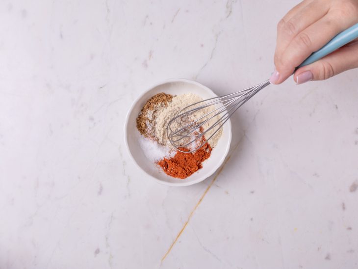 Um recipiente com os ingredientes secos misturados com um fouet.
