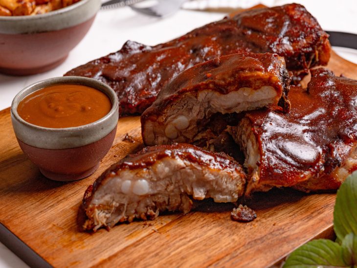 Uma tábua com costelinhas barbecue.