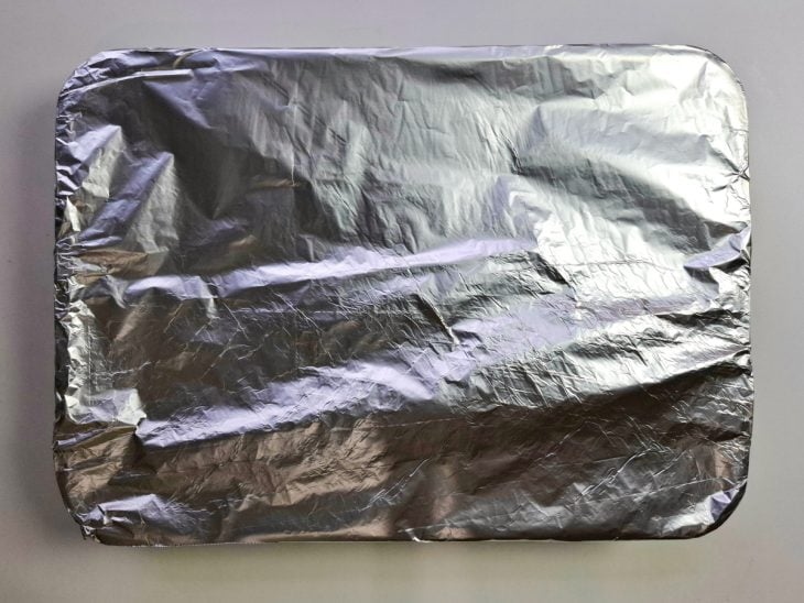Assadeira coberta por papel alumínio.