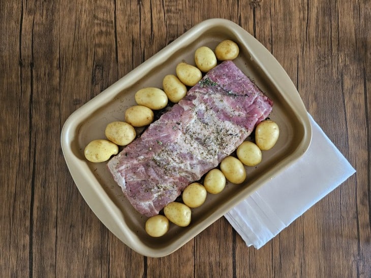 Costelinha temperada com batatas bolinha ao redor.
