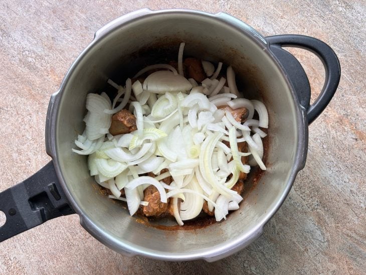 costelinha de porco já cozida e cebola para refogar.