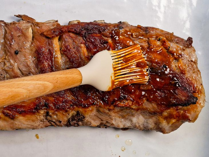 Molho barbecue sendo pincelado na carne.
