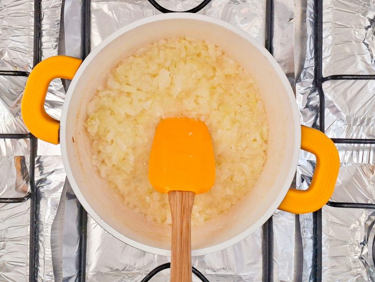 Cebola e alho picados sendo refogados no óleo até dourar.