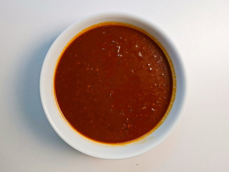 Molho pronto e reservado, com textura encorpada e coloração intensa.