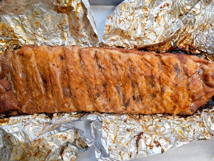 Costelinha assada sendo desenformada após o tempo de forno.