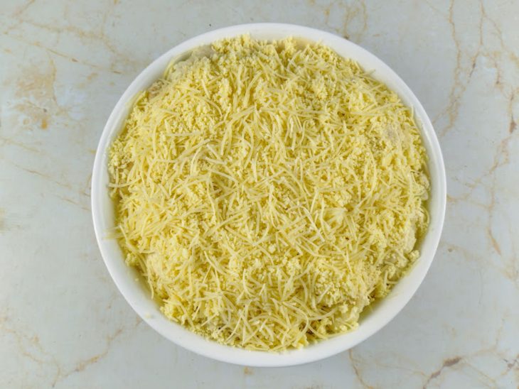 queijo em fatias e ralado distribuído por todo o refratário.