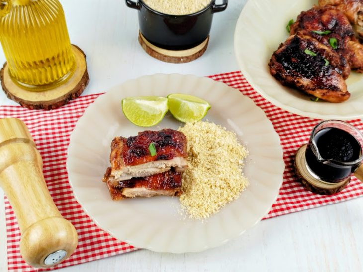 Coxa e sobrecoxa assada servida com farofa.