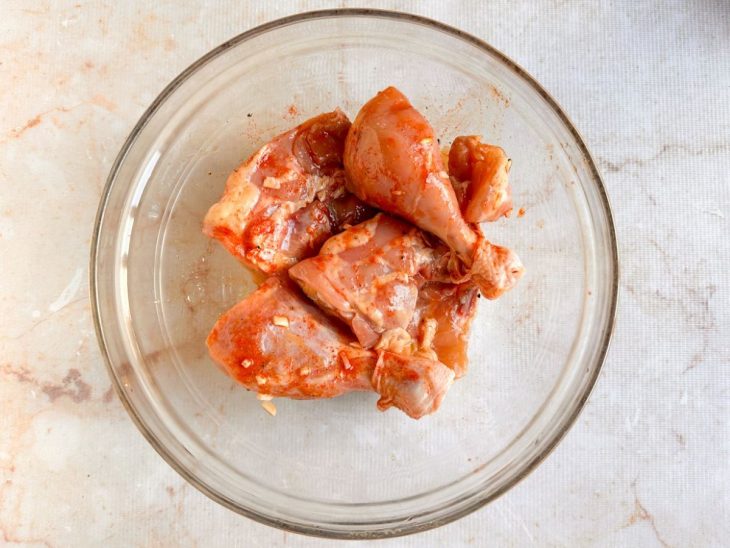 Coxa e sobrecoxa temperadas na tigela.