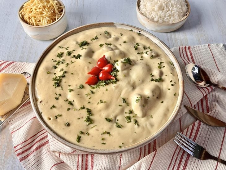 Refratário com carne com creme de batata decorado com cheiro-verde e pimenta biquinho.