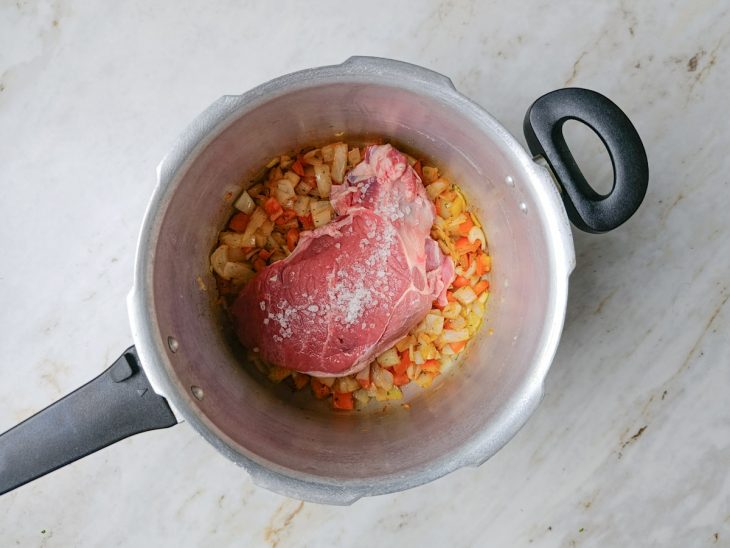 Coxão mole inteiro ou em pedaços grandes sendo colocado na panela.