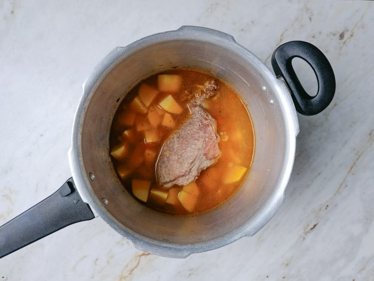 Batatas adicionadas à panela com a carne já cozida.