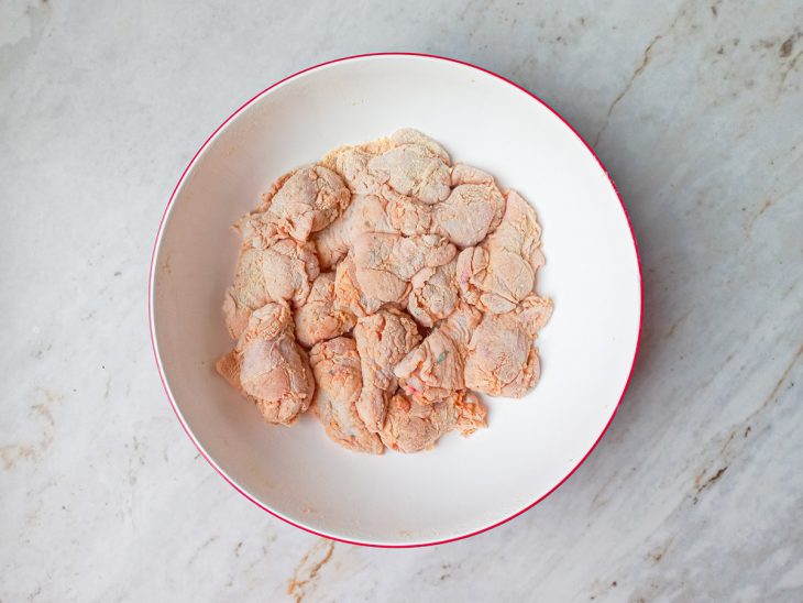 Frango misturado aos secos no recipiente.