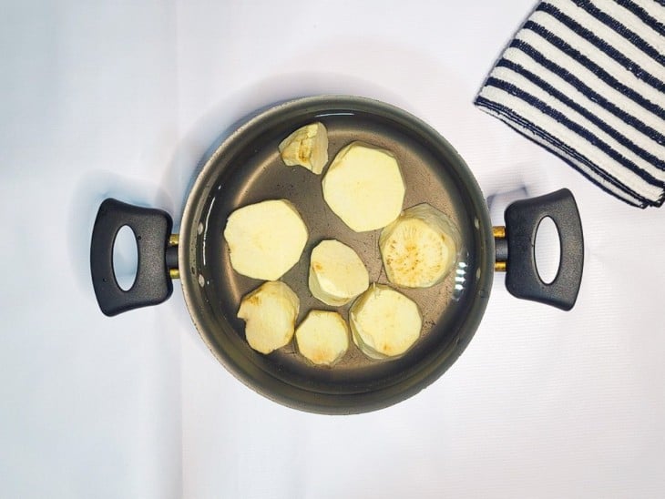 Uma panela com água e batata-doce descascadas.