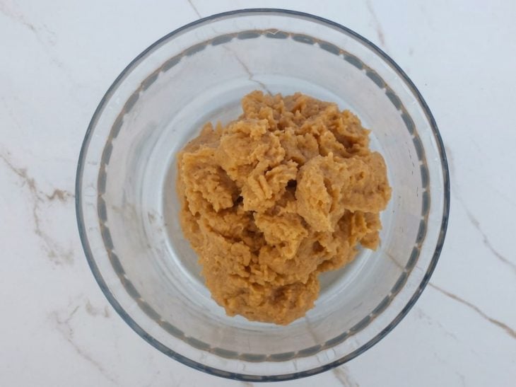 Ingredientes secos sendo adicionados aos poucos na tigela e mexidos até formar a massa.