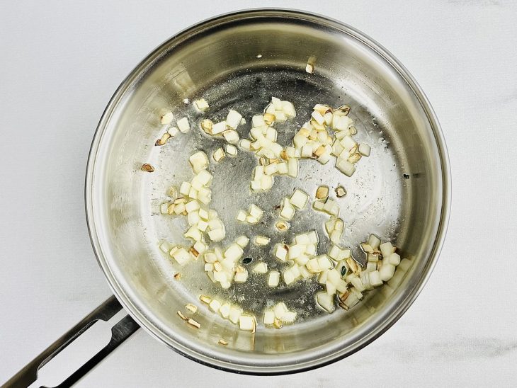 Na frigideira, a cebola refogada na manteiga.