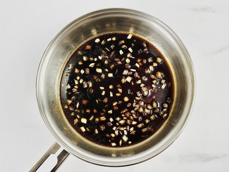 Shoyu e mel adicionados, molho escuro e consistente.