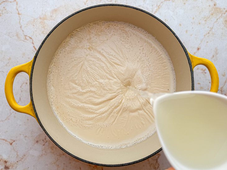 Suco de limão sendo adicionado ao leite quente.