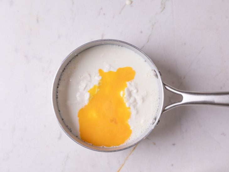 Panela com a mistura de amido, leite, leite condensado, creme de leite e gemas.