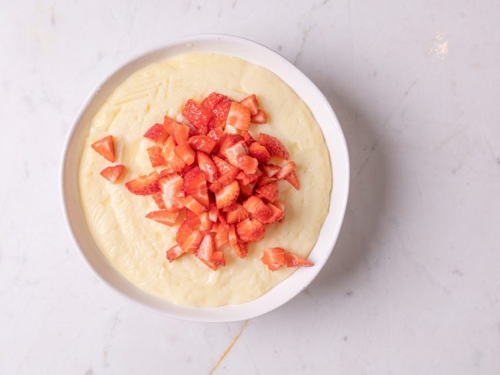 Um recipiente com o creme misturado com o morango picado.