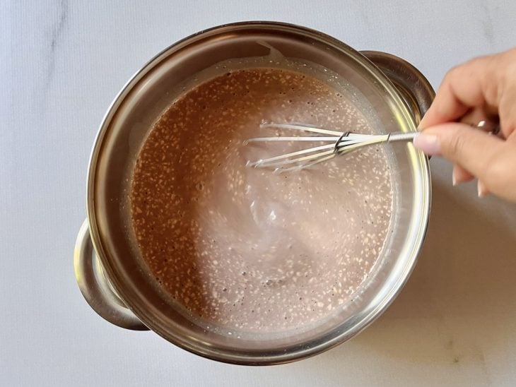 Mistura da jarra e creme de leite despejados na panela.