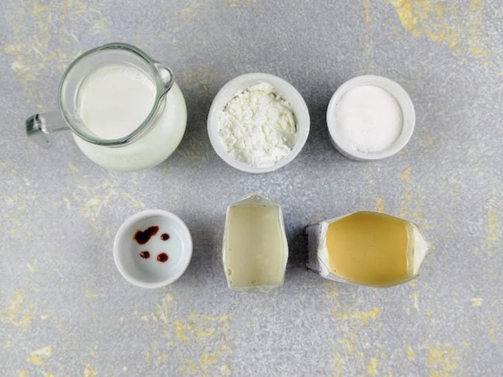 Ingredientes para a receita de creme belga sem ovo reunidos em uma bancada.