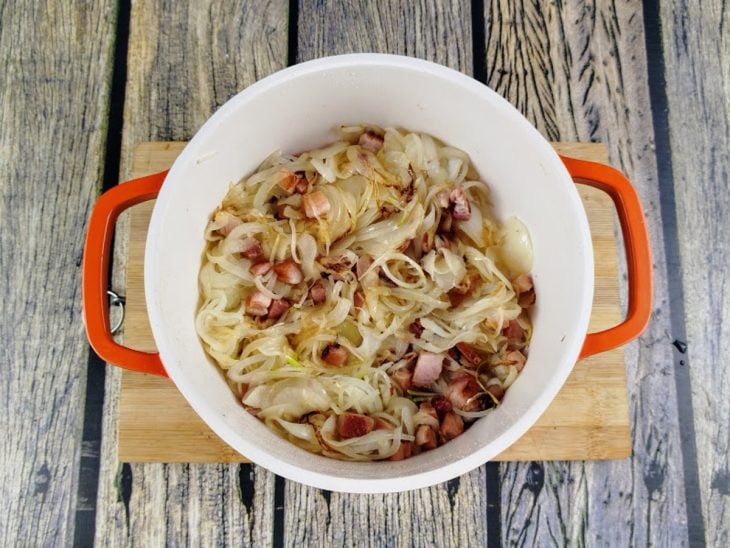 Uma panela com o bacon e a cebola fatiada.
