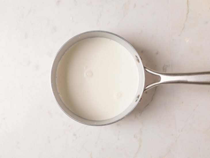 Panela com creme de leite aquecido.