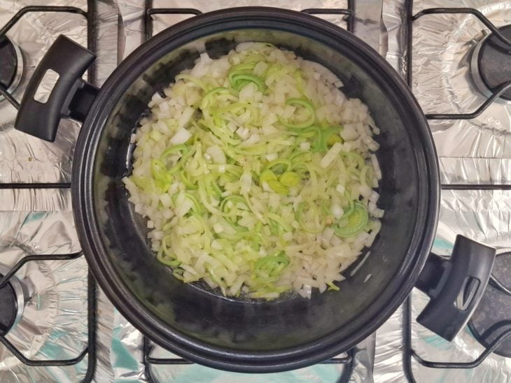 Cebola e alho-poró em uma panela.