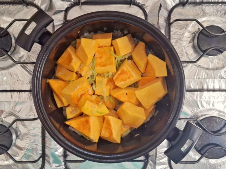 Pedaços de abóbora, sal e gengibre adicionados na panela.