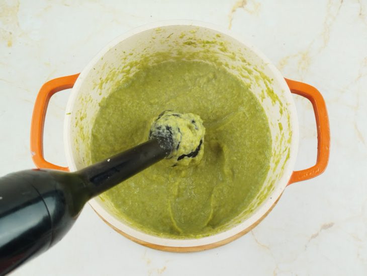 Aspargos, cebola e alho sendo batidos no processador.