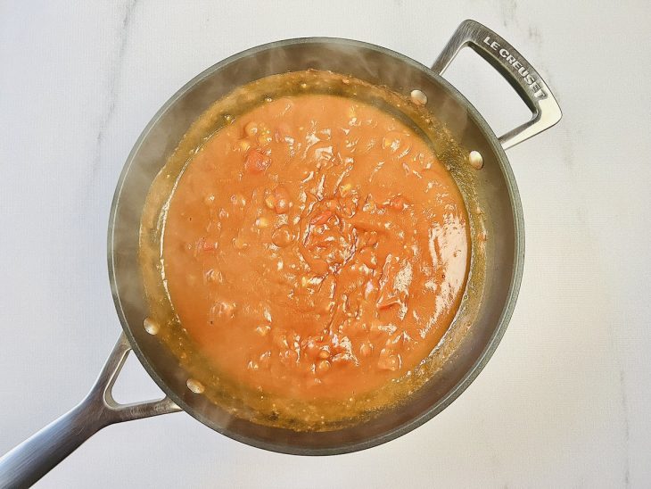 Tomate e água adicionados a frigideira.
