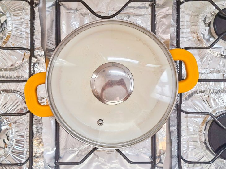 Leite, creme de leite e baunilha aquecendo juntos na panela.