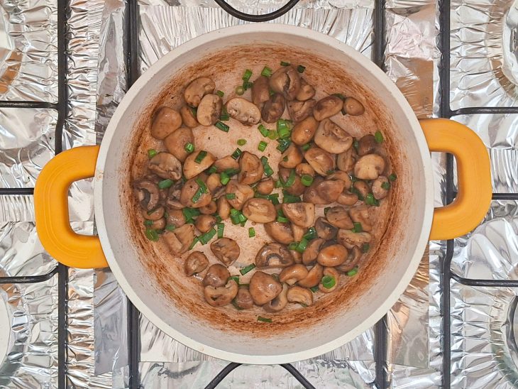 Cogumelos dourando no azeite com cebolinha.