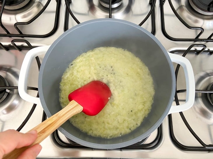 Uma panela com cebola e alho refogados na manteiga.